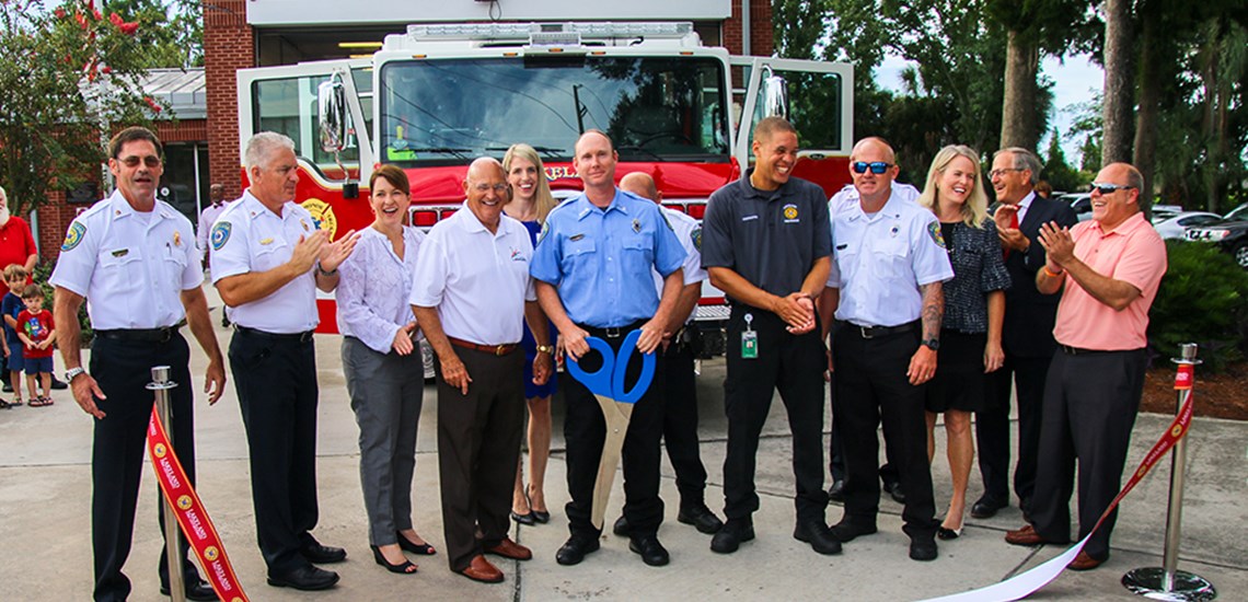 Dignitaries and design committee members cutting ribbon for new fire engine 51
