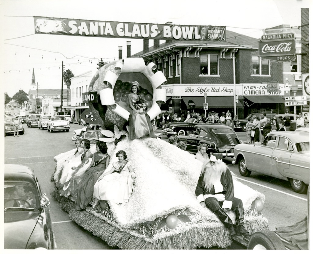 A float carrying Miss Santa Claus Bowl and her court passes through the downtown Lakeland at Main Street and Florida Avenue during the annual Santa Claus Bowl parade in 1952.; link to I Love a Parade album