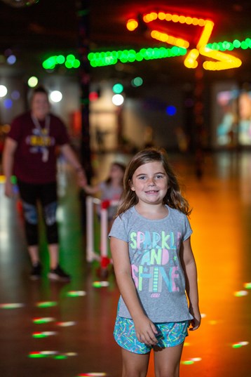 Little girl in the foreground wearing shirt that says "sparkle and shine"