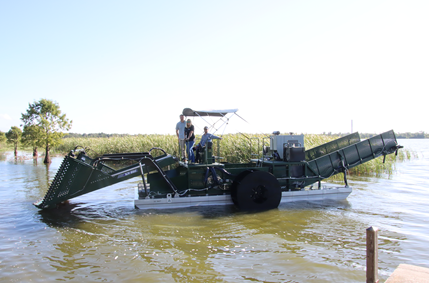 aquatic harvester with city staff, in a lake