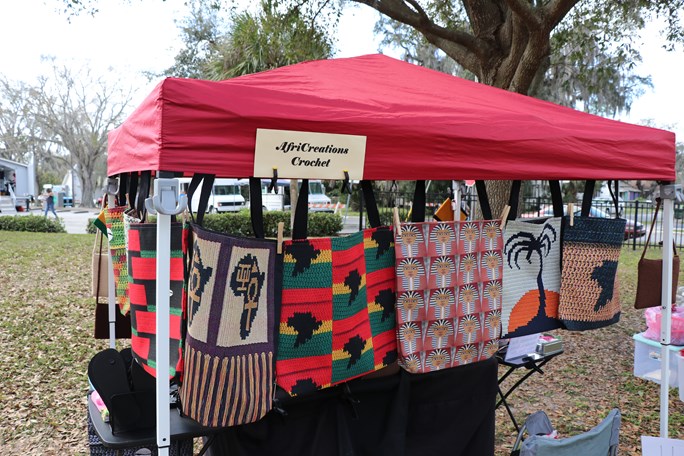 ten by ten pop-up tent with handmade purses hanging from the tent in Jackson Park