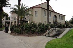 West exterior of the Magnolia Building with stairs leading up to the parking lot and Hollis Garden