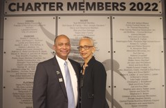 Man and woman posing in front of Charter Members 2022 sign in Lakeland History and Culture Center exhibit room