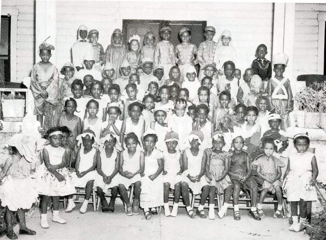 Children dressed in costumes pose outside the Moorehead Graded School circa 1950s