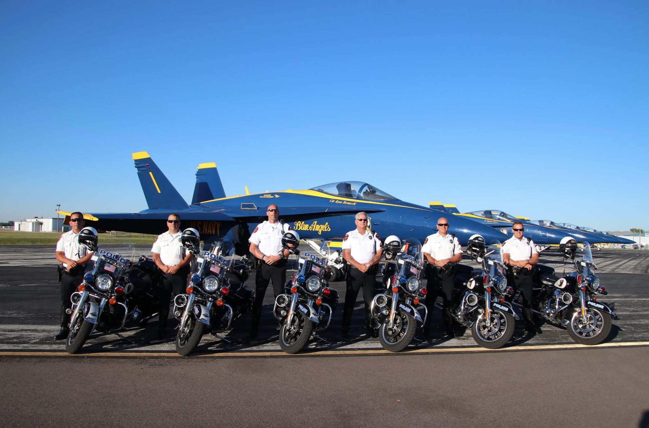 A picture of the Lakeland Police Department Traffic Unit in front of a Blue Angels jet