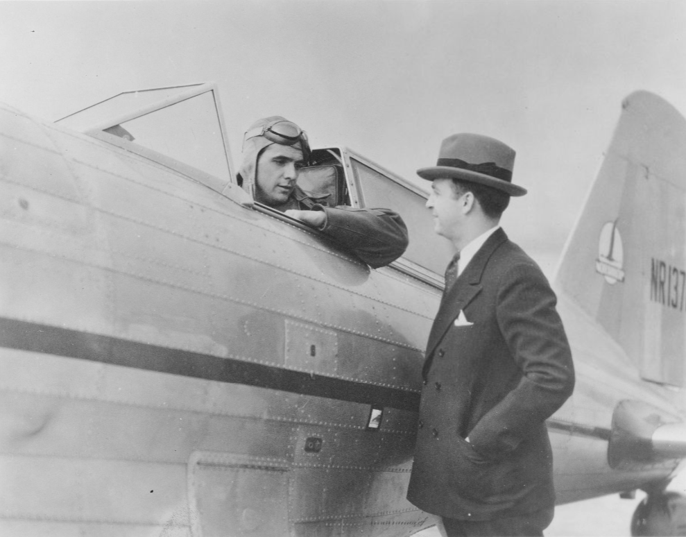 Howard Hughes sits in the cockpit of a Northrop Gamma 2G racer as he talks to aviation industry colleague Albert Lodwick.