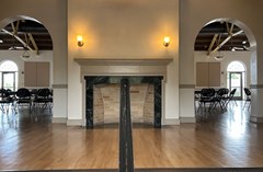 Fireplace and entry space of the Magnolia Building. Handrail for stairs in the middle.