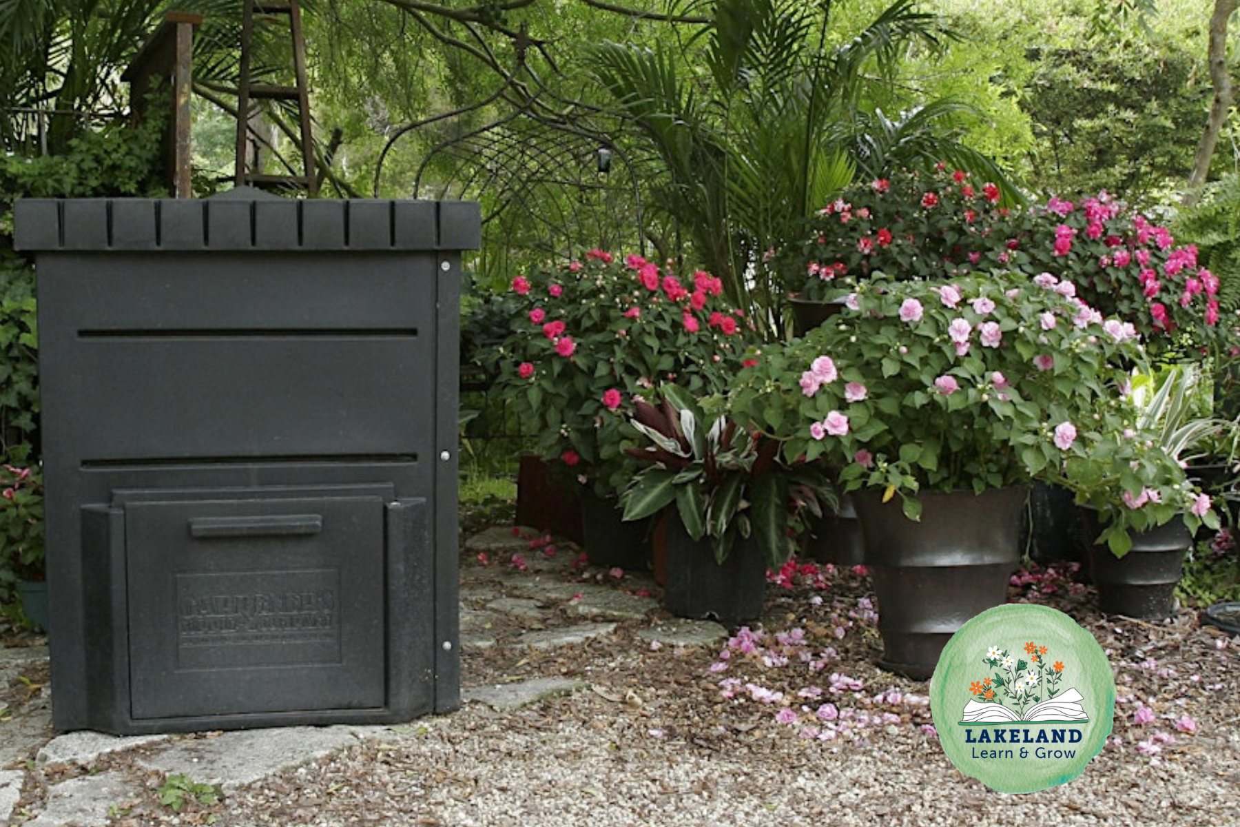 Compost Bin in landscape. Lakeland Learn and Grow Logo with open book and flowers.