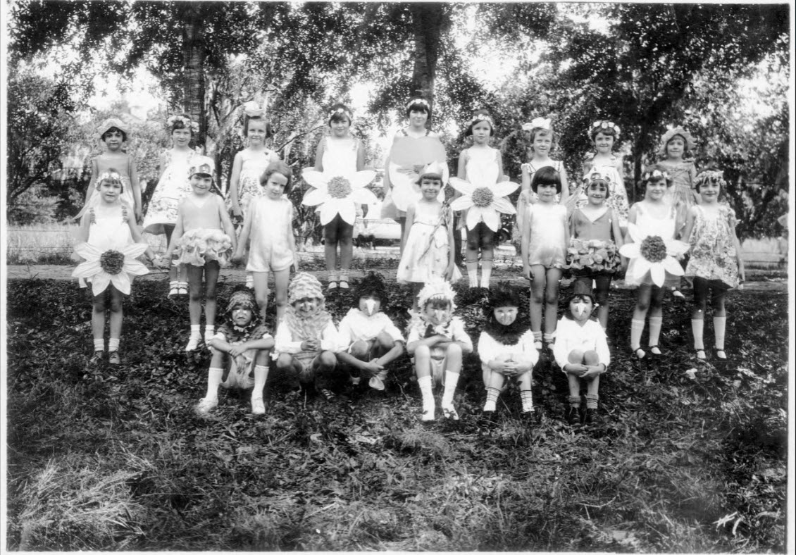 First and second grade students at the Child's Garden of Learning in Lakeland, Florida pose in costumes on the school grounds in 1929. Some of the students are holding daisies, which was the school symbol; link to "Child's Garden of Learning" contentDM collection