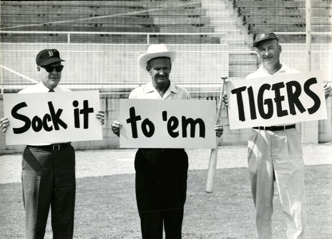Joker Marchant holds part of a sign "Sock it to 'em tigers" cheering on the Spring Training game of the Detroit Tigers team in 1964.; link to contentDM "Perkins-Phillips Photographs" collection