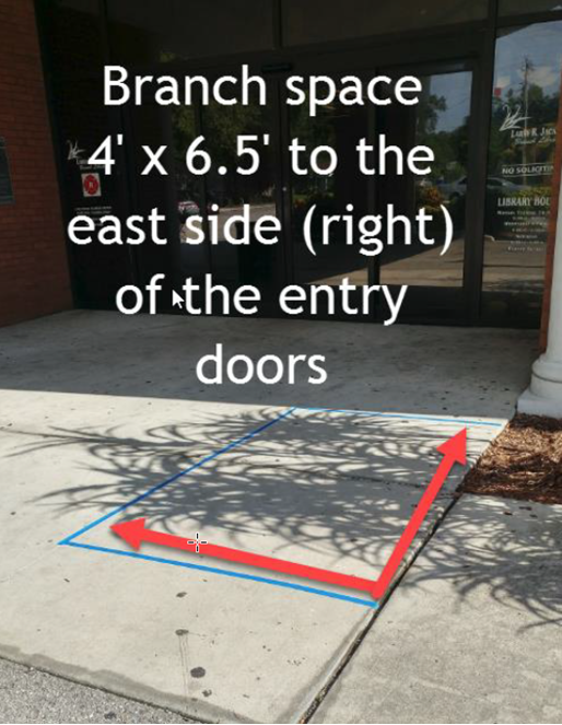 Photograph showing the designated petitioning space at Larry R. Jackson Branch Library. Right of entry, red arrows delineating a four foot by six-and-a-half foot space.