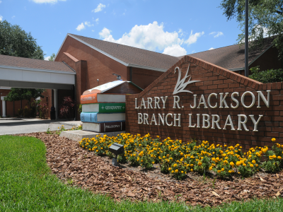 Larry R. Jackson Branch Library sign with stacked books